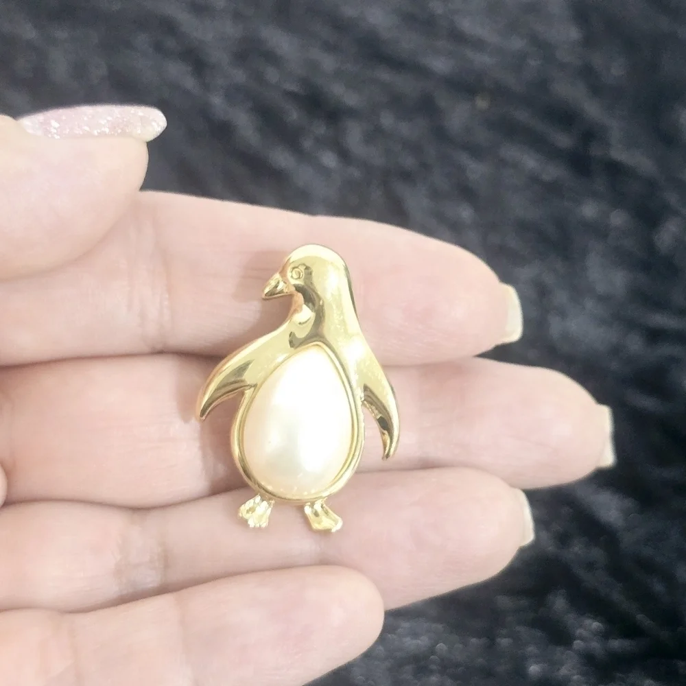Monet Jewelry Two gold-tone leaf and penguin brooches